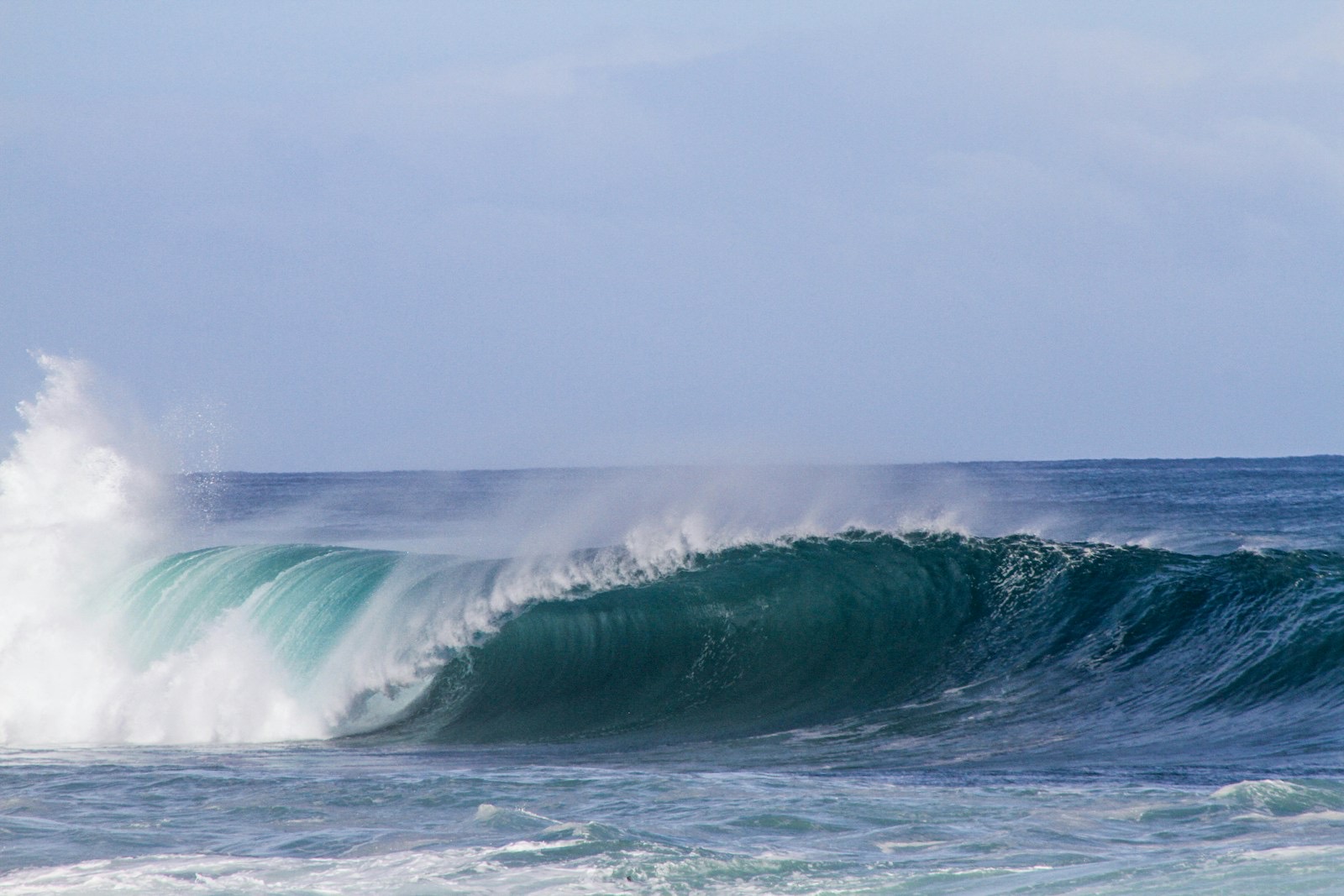 A wave breaking under grey cloud